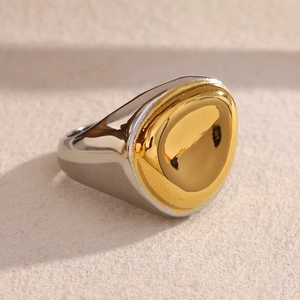 Close-up of minimalist bicolor signet ring featuring a polished gold circular inlay top