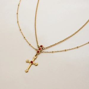Detail einer zweilagigen Goldkette mit rotem Türkis und Kreuzanhänger-Schmuck