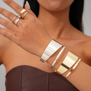 Detail of irregular metal ring and bracelet set in gold and silver finish on model