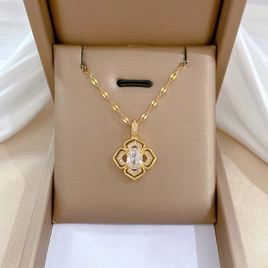 Collier trèfle doré luxueux avec cristaux sur un fond élégant en soie blanche