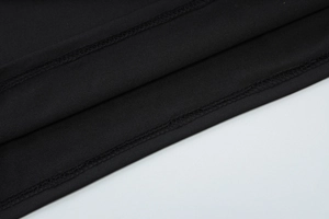 Detailed macro view of the professional stitching on a black elastic knit fabric hem