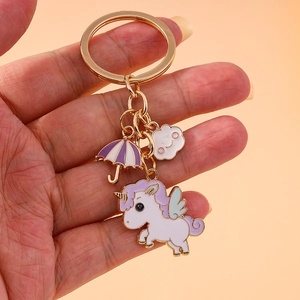 Golden unicorn keychain with purple umbrella and pink cloud charms for handbags