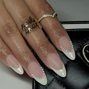 French almond press-on nails with white pearl trim on a nude pink base for women