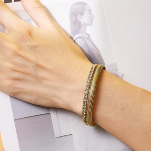 Detail view of gold layered bracelet with sparkling zircons and chevron texture on wrist
