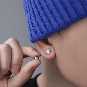 Close-up of black and white zircon stud earrings on model for a trendy minimalist look