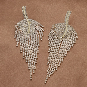 Detail of elegant gold leaf earrings featuring sparkling rhinestones and long tassels