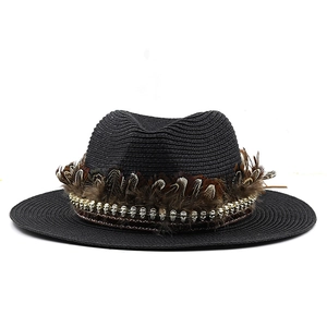 Detail of black straw fedora with patterned feathers and silver metal skull accents