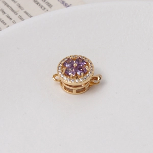 Macro detail of gold flower clasp with purple heart zircons for jewelry making