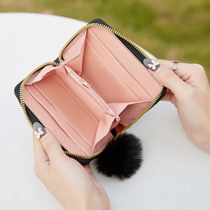 Quilted women's small wallet with card slots, pink interior, and black pompom charm