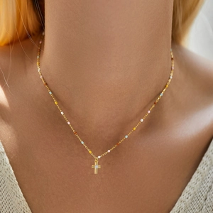 Gold s925 silver necklace with colorful beads and a small sparkling cross pendant