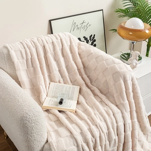 Thick checkered plush blanket in cream white draped over a modern sofa in a cozy interior