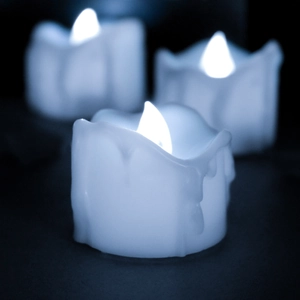 Close-up of three LED flameless candles with white wax-dripping texture for party decor