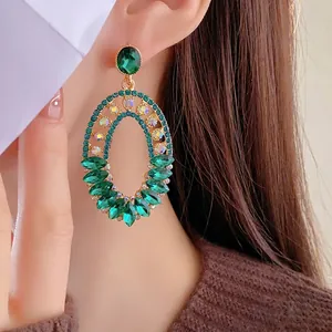 Vintage emerald-style hollow oval earrings with gold metal base and sparkling green gems