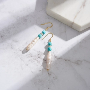 Macro detail of Bohemian earring with baroque pearl and turquoise beads on 925 silver