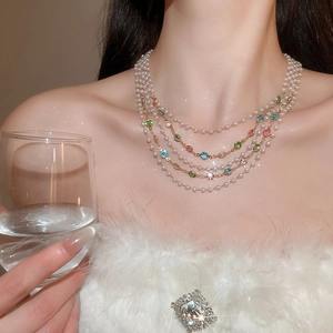 Gros plan d'un collier de perles vintage multicouches avec pierres gemmes de couleur