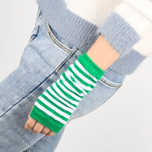 Close-up of green and white striped knit arm warmers worn by a model in casual style