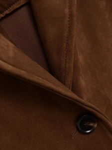 Detail shot of a brown faux suede blazer showing collar stitching and resin button texture
