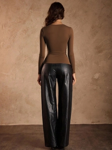 Vista trasera de camiseta marrón de manga larga y pantalones de cuero de cocodrilo