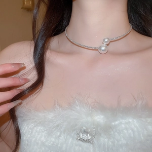 Detail of silver choker necklace with rhinestones and asymmetric pearls on model