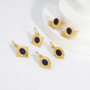 Détail d'un ensemble de boucles d'oreilles dorées avec pierres bleues aux formes rétro