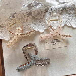 Elegant crystal flower hair claws in champagne, pink, and grey resin with rhinestones