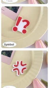 Close-up of creative red acrylic emoji pins with exclamation and anger symbols