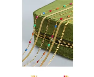 Détail de colliers triple épaisseur en titane doré avec perles émaillées sur velours