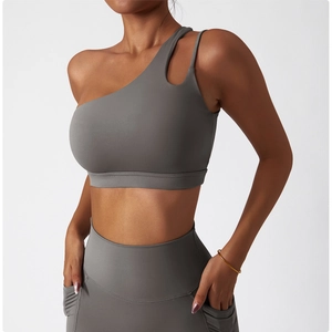 Macro detail of high-elastic grey yoga set featuring one-shoulder cutout design and pockets