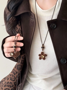Detail of leopard print heart and flower resin pendants with rhinestones on long cord