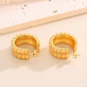 French vintage textured C-shaped gold earrings in stainless steel on stone background