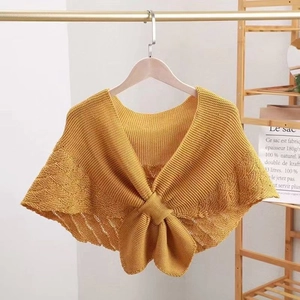 Detail of ginger knit shawl featuring a hollow pattern and elegant bow decoration
