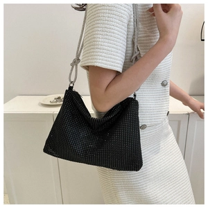 Detail shot of a black rhinestone hobo bag with a stylish silver chain knot shoulder strap