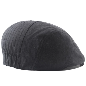 Detail view of the black cotton newsboy cap showing neat stitching and elastic band back
