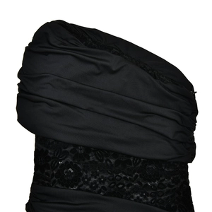 Close-up of black ruched fabric and intricate lace floral patterns on the dress