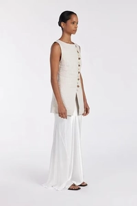 Detail of the side buttons and slit design on a beige sleeveless top and long skirt set