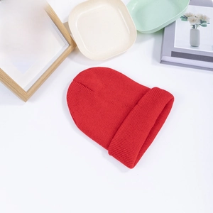 Classic red ribbed knit beanie with wide cuff for men and women on aesthetic background