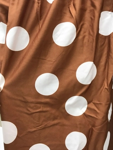 Nahaufnahme des braunen Kleiderstoffs mit hochwertigem weißem Polka-Dot-Print-Muster