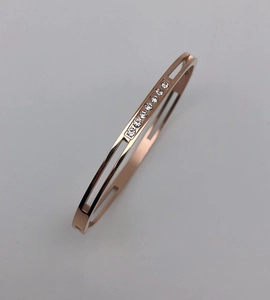 Macro view of rose gold hollow bangle with 8 sparkling cubic zirconia stones