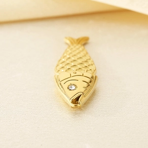 Détail macro d'un pendentif carpe koi en or 18k avec écailles et œil en pierre précieuse