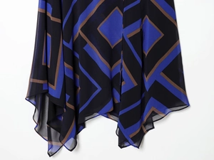 Dettaglio dell'orlo asimmetrico con stampa geometrica a rombi su chiffon trasparente