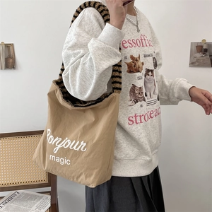 Canvas tote bag with 'Bonjour' text and fluffy striped strap shown on a model