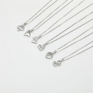 Minimalist silver letter necklace with hexagonal honeycomb texture on white background