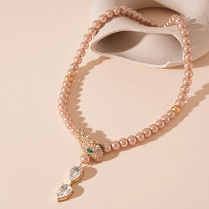 Detailed close-up of pink imitation pearl necklace with crystal snake head and water drop charms