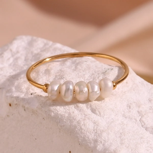 Macro shot of five natural white pearls set on a thin 18K gold plated stainless steel ring
