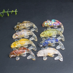 Detailed view of eight colorful crystal koi fish statues with gold foil on black surface