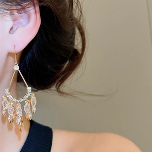 Close-up of gold-plated tassel earrings with zircon water droplets on model