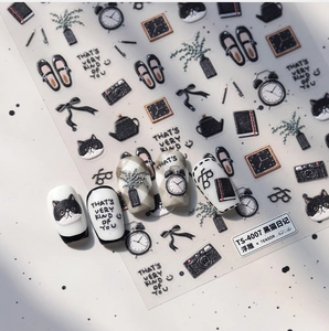 Detail of Black Cat Diary embossed nail stickers with hand-drawn camera and bow motifs