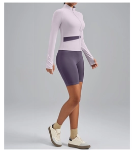 Detail of lavender high neck yoga jacket with thumb holes and purple biker shorts set