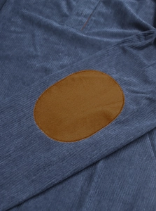 Close-up of navy knit long-sleeve shirt featuring brown oval elbow patch detail