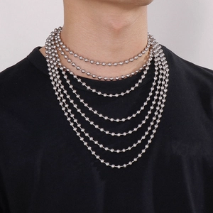 Detailed macro view of layered stainless steel ball bead chains worn on model's neck